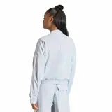 Campera tipo bomber Adidas, color gris claro, con cierre frontal, bolsillos laterales y las icónicas tres tiras blancas en las mangas. Presenta cuello redondo y puños elásticos.