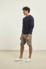 Sweater de punto fino azul con cuello redondo y terminaciones elásticas en canalé.