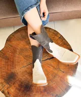 Botas texanas de cuero combinadas en color crudo y marrón, con caña media, punta cuadrada y diseño bordado en el empeine.