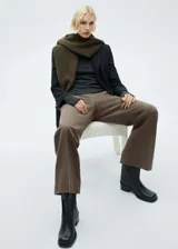 Pantalon de vestir de tiro medio con corte flare y diseño largo. Cuenta con dos bolsillos laterales y cierre frontal con cremallera, botón y ganchos ocultos bajo tapeta.