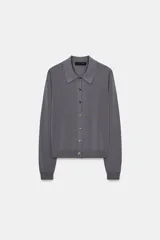 Chaqueta de punto gris oscuro, de manga larga, con cuello solapa y cierre frontal de botones dorados.