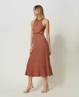 Vestido midi de punto color ladrillo con lurex, cuello halter con abertura en forma de lágrima y falda plisada con cortes en los laterales.