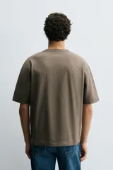 Camiseta de corte relajado confeccionada en algodón compacto, con cuello redondo y mangas cortas sin costura de sisa.