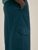 Falda larga color coral, estilo cargo, con cintura ajustable, tajo en el frente y bolsillos laterales.