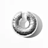 Aro plateado tipo trepador con textura irregular. Se coloca a presión en la parte superior de la oreja y se ajusta al lóbulo.