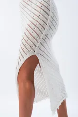 Pollera midi de tejido calado color blanco, con cintura elástica y abertura lateral.