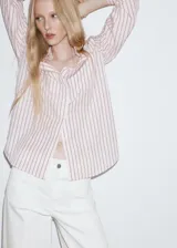 Jeans estilo wide leg de tiro alto en color blanco, con bolsillos de parche delanteros y cierre de cremallera y botón.