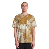 Remera Volcom con estampado camuflado en tonos mostaza y beige, de manga corta, con cuello redondo y un bolsillo aplicado en el pecho que incluye un parche estampado de la marca.