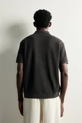 Polo regular fit color blanco, de manga corta con cuello solapa, abertura frontal y acabado en rib con textura de rayas verticales.