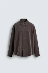 Camisa de corte relajado confeccionada en tejido fluido con mezcla de lyocell. Presenta cuello solapa, manga larga, cierre frontal con botones y un acabado con efecto lavado.