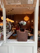 Bolso tipo tote bag de cuero trenzado a mano, en tonos marrón y negro, con asas trenzadas.