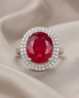 Anillo de plata 925 con piedra central ovalada de raíz de rubí en color rojo intenso, rodeada por un engaste de circonias brillantes.
