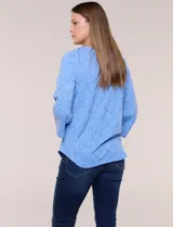 Blusa celeste de tejido texturado con relieve floral, escote redondo con muesca central, mangas tres cuartos estilo campana y ruedo curvo.