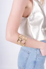 Brazalete dorado para el brazo, con diseño calado a mano.