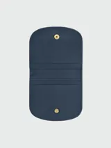 Tarjetero/mini bolso de cuero azul marino, con solapa redondeada y cierre a presión dorado con el logo de un caballo al galope.