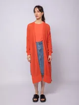 Sacón largo de tejido de punto color naranja, con diseño de calados y aberturas laterales.