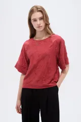 Blusa de viscosa color marrón rojizo, con diseño holgado, cuello a la base, mangas cortas y detalle de bordado floral en tono sobre tono.