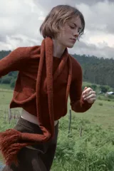 Jersey de punto de manga larga con cuello redondo y diseño asimétrico que incorpora una pieza tipo bufanda integrada con terminación en flecos.