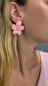 Aros tipo caravana con forma de flor color rosa y centro dorado.
