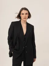 Blazer negro con finas rayas verticales, de corte holgado y solapas clásicas.