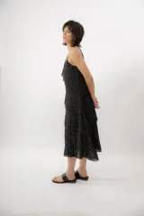 Vestido midi negro con estampado de lunares blancos, escote en V, breteles finos y diseño con volados en capas.
