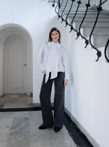 Camisa negra de algodón con cuello con lazo desmontable y mangas largas.