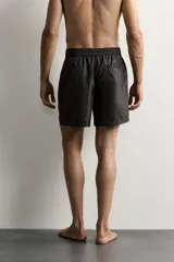 Short de baño negro de tejido técnico, con cintura elástica ajustable con cordón, bolsillos laterales y forro interior, perteneciente a la colección especial Aaron Levine x Zara.