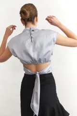 Top corto de seda color verde esmeralda, con cuello mao y mangas cortas.