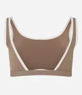 Top deportivo de microfibra con escote redondo delantero y escote en V en la espalda. Presenta un diseño bicolor con cuerpo en color crema y ribetes en color marrón oscuro, breteles anchos y copas desmontables.