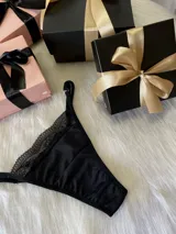 Tanga negra de lycra y encaje, con tiras regulables y forro de algodón.