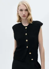 Chaleco negro de tejido de punto con textura, cuello redondo, sin mangas y cierre frontal con botones dorados.