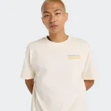 Remera de algodón color crema con cuello redondo y mangas cortas. Presenta un pequeño gráfico con texto en amarillo y una línea horizontal debajo en el pecho.