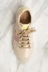 Zapatilla urbana de cuero color beige con detalles en rosa y amarillo.
