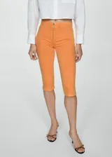 Pantalón capri de tiro medio con cierre frontal de cremallera, corte ajustado y diseño de cinco bolsillos.