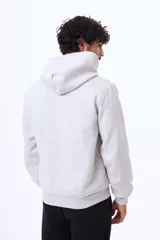 Buzo con capucha y bolsillo frontal tipo canguro, confeccionado en tela de felpa, con cordones ajustables en el cuello y puños elásticos.