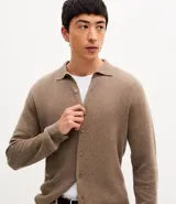 Camisa de punto de manga larga con cuello tipo polo y cierre frontal abotonado. Presenta un diseño de textura fina y corte recto.