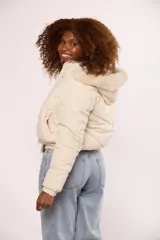 Campera bomber de nylon color rosado, con diseño acolchado, cierre frontal con cremallera y botones a presión, y capucha con borde de piel sintética al tono.