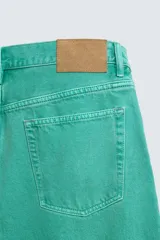 Jeans de mezclilla de corte recto, tiro medio, color verde vibrante con efecto lavado. Presenta cierre frontal con cremallera y botón, y cinco bolsillos.