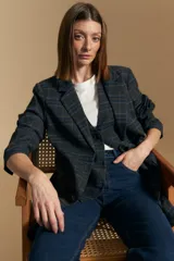 Blazer de corte sastrero con diseño de cuadros en tonos oscuros, solapas clásicas y cierre frontal con botones. Presenta una estructura estructurada pero cómoda, ideal para un look formal o casual.