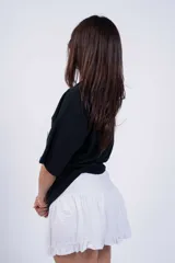 Minifalda negra de tussor con cintura elastizada y volado en el ruedo.