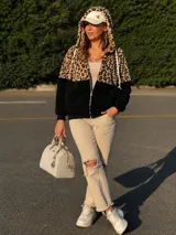 Campera tipo polar con cierre frontal, confeccionada en una combinación de tela con estampado animal print de leopardo en la parte superior y capucha, y tela lisa color bordó en la parte inferior. Cuenta con mangas largas y puños elásticos.