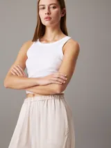 Pantalón de satén color crema, con cintura elástica, corte holgado y bolsillos laterales.