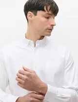 Camisa de manga larga de tejido Oxford color celeste, con cuello button-down, cierre frontal de botones y un bolsillo aplicado en el pecho.