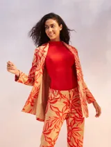 Blazer color beige con estampado de hojas en tonos rojos y naranjas, de corte recto y solapa clásica.