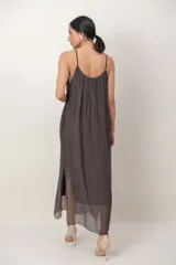 Vestido midi de gasa negro, con solera sin mangas, escote fruncido y detalle de aplique floral en el hombro.