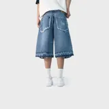 Bermuda baggy de denim color azul, con diseño holgado, bolsillos traseros con detalles deshilachados y dobladillo inferior ancho con efecto desgastado.
