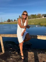 Vestido corto blanco tejido en hilo de algodón, con detalles de crochet en contraste negro en el cuello, sisas y ruedo.