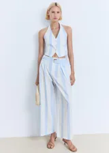 Pantalón de tiro medio con diseño culotte y estampado de rayas verticales celestes y blancas. Cuenta con trabillas, cinturón ajustable incorporado y cierre oculto.