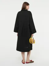 Vestido camisero oversized color beige, confeccionado en 83% ramié y 17% algodón, con mangas amplias, puños altos y cartera con botones delanteros.