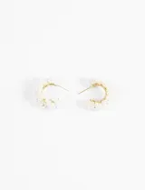 Par de aros tipo argolla dorados, decorados con perlas blancas de diferentes tamaños.
